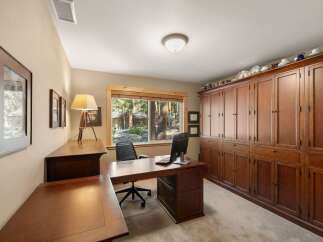 This home office features a spacious L-shaped wooden desk with a computer and a comfortable office chair, perfect for productivity.