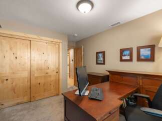 This home office features a spacious wooden desk with a computer and keyboard, perfect for productivity.