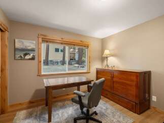 This cozy home office space features a rustic wooden desk and a comfortable grey office chair, perfect for productive workdays.