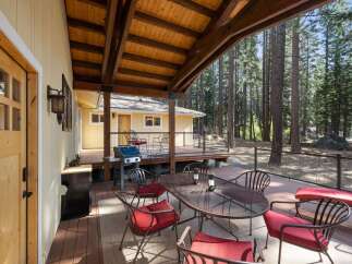Enjoy outdoor living with this spacious deck, perfect for entertaining or relaxing amidst a serene forest setting.