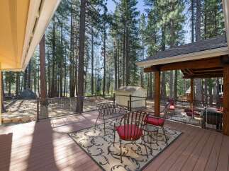 Enjoy the serene mountain lifestyle from this expansive deck, perfect for entertaining or quiet relaxation amidst towering pine trees.