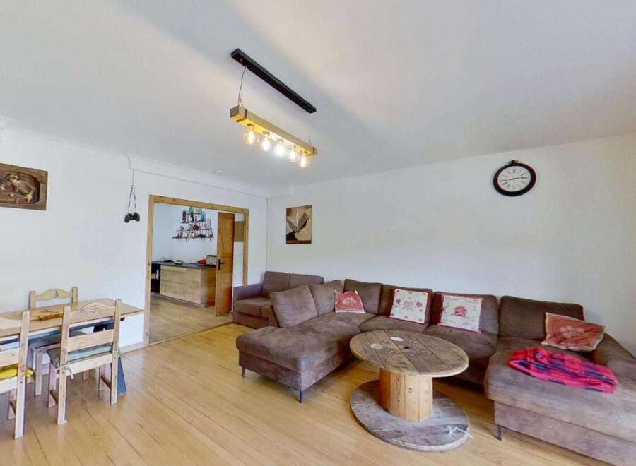 This inviting living space features a spacious sectional sofa perfect for relaxation, complemented by a unique wooden spool coffee table.