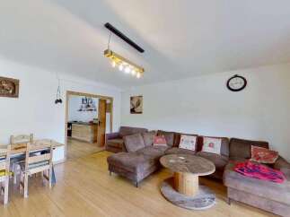 This inviting living space features a spacious sectional sofa perfect for relaxation, complemented by a unique wooden spool coffee table.
