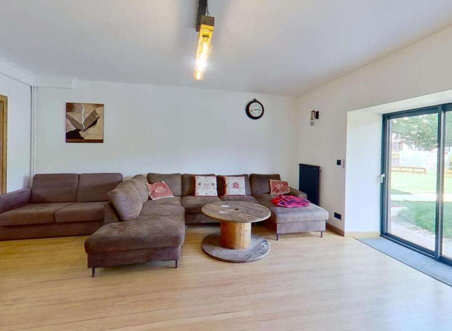 Experience comfort and style in this spacious living room, featuring a large sectional sofa perfect for gatherings.