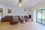 Experience comfort and style in this spacious living room, featuring a large sectional sofa perfect for gatherings.