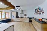 Discover this stunning modern kitchen featuring sleek, light wood cabinetry and a spacious black countertop.