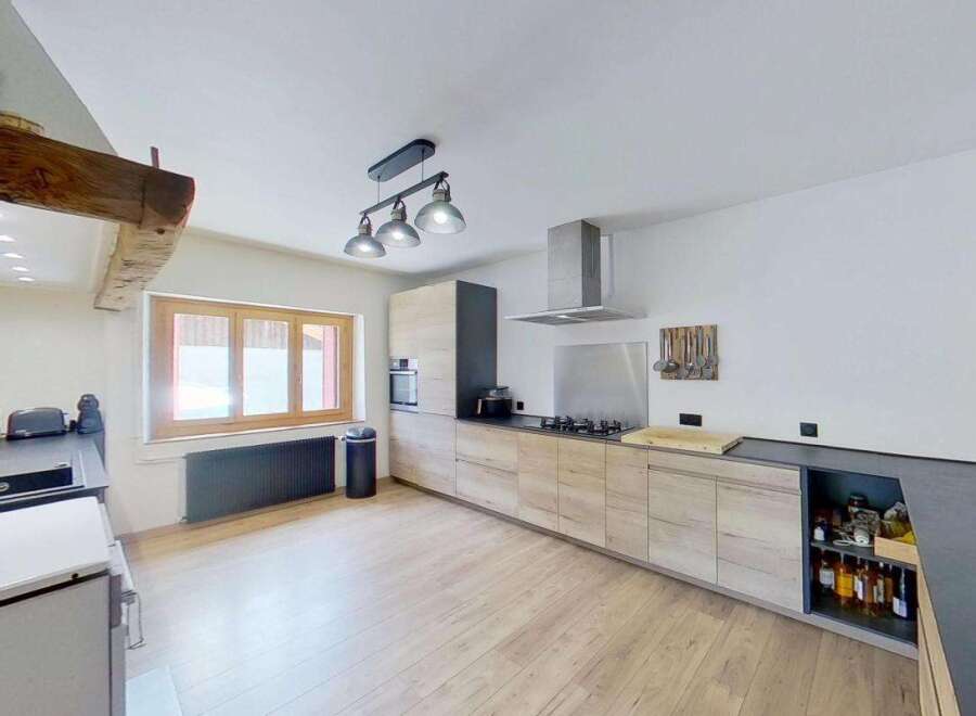 Discover this charming kitchen featuring modern light wood cabinetry and sleek dark countertops.