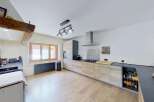 Discover this charming kitchen featuring modern light wood cabinetry and sleek dark countertops.