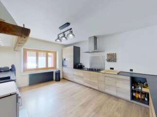 Discover this charming kitchen featuring modern light wood cabinetry and sleek dark countertops.