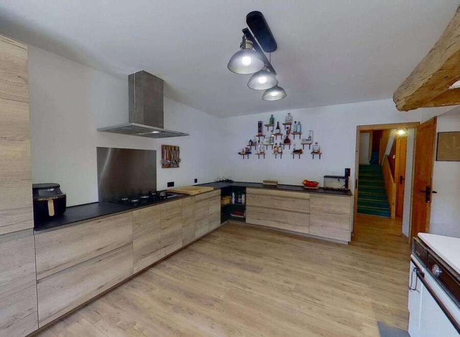 Discover this charming kitchen featuring modern light wood cabinetry and sleek black countertops.