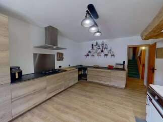 Discover this charming kitchen featuring modern light wood cabinetry and sleek black countertops.