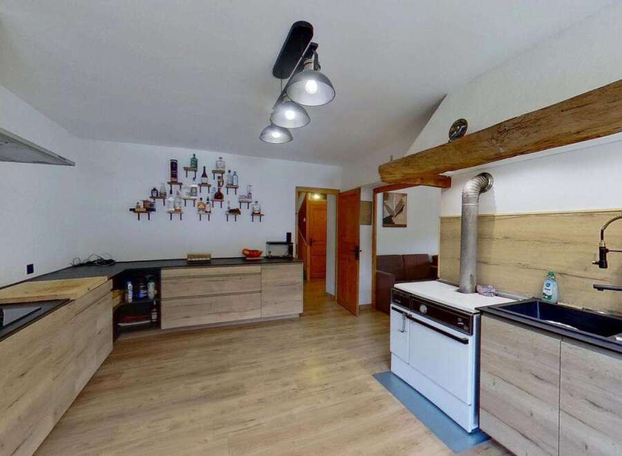 Discover this charming kitchen featuring modern wooden cabinetry and sleek black countertops.
