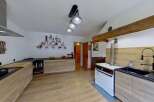 Discover this charming kitchen featuring modern wooden cabinetry and sleek black countertops.