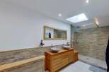 Experience modern luxury in this stunning bathroom featuring a spacious walk-in shower with elegant stone tile accents.