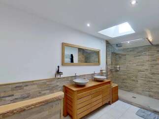 Experience modern luxury in this stunning bathroom featuring a spacious walk-in shower with elegant stone tile accents.
