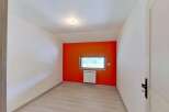 This room features a striking orange accent wall, creating a vibrant focal point.