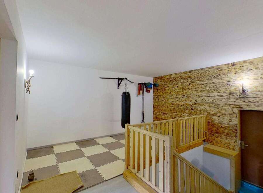 Discover a versatile space perfect for your fitness goals, featuring a professional-grade punching bag and pull-up bar.