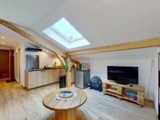 Discover this charming attic apartment featuring exposed wooden beams and a bright skylight, creating a warm and inviting atmosphere.