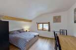 Discover this charming bedroom featuring a comfortable bed with patterned bedding and a bedside lamp for a cozy ambiance.