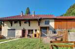 Discover this charming property featuring a spacious house with a red tile roof and a rustic wooden extension.