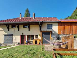 Discover this charming property featuring a spacious house with a red tile roof and a rustic wooden extension.