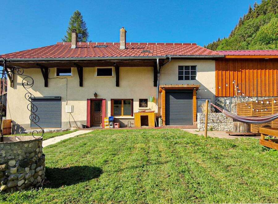 Discover this charming property featuring a traditional stone well and a lush green lawn, perfect for outdoor relaxation.