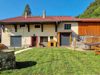 Discover this charming property featuring a traditional stone well and a lush green lawn, perfect for outdoor relaxation.
