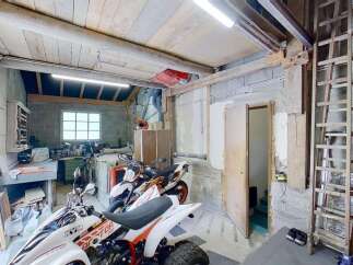 Discover this versatile garage space, perfect for storing vehicles like motorcycles and ATVs, or as a workshop area.