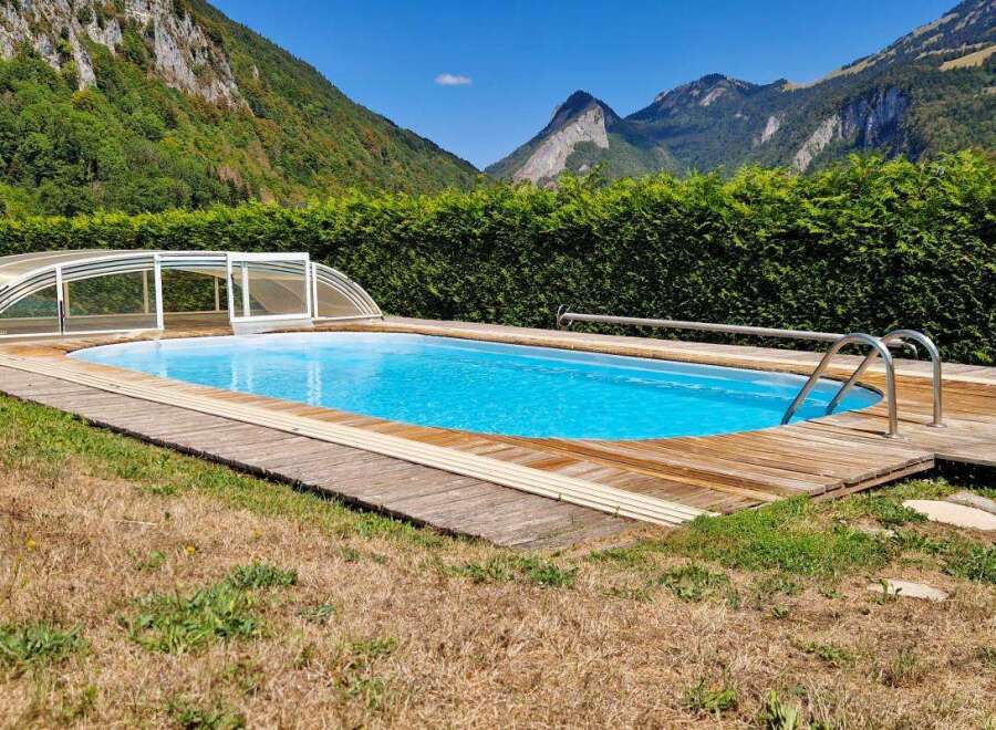 Enjoy a refreshing dip in this stunning outdoor swimming pool, complete with a retractable cover for year-round use.