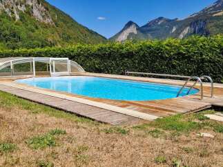 Enjoy a refreshing dip in this stunning outdoor swimming pool, complete with a retractable cover for year-round use.