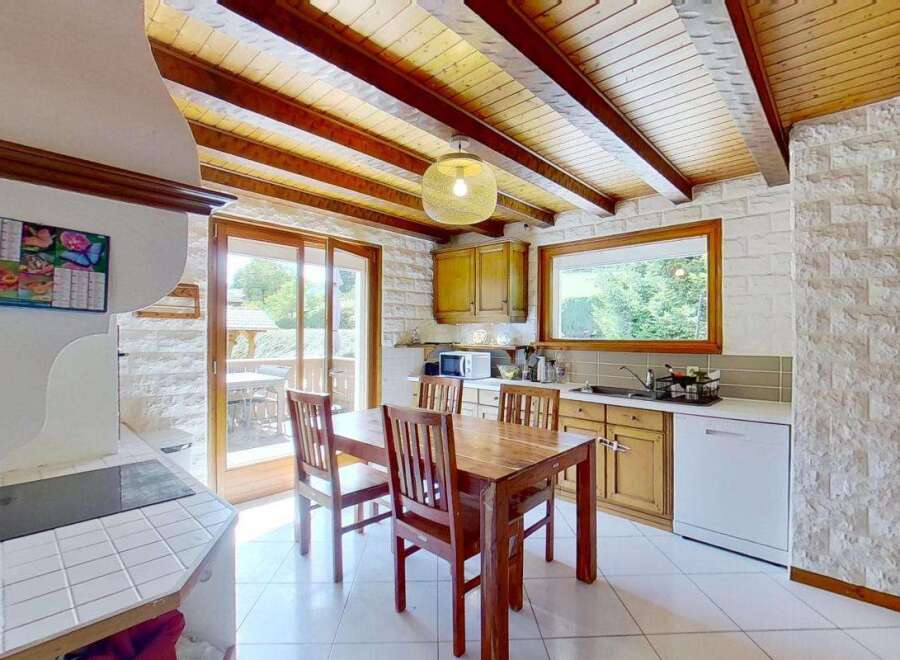 This charming kitchen features a rustic wooden dining table and chairs, perfect for family meals.