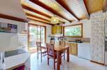 This charming kitchen features a rustic wooden dining table and chairs, perfect for family meals.