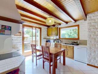This charming kitchen features a rustic wooden dining table and chairs, perfect for family meals.