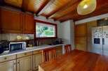 Discover this charming kitchen featuring warm wooden cabinetry and a rustic beamed ceiling.