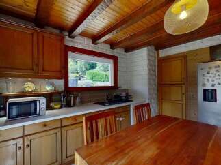 Discover this charming kitchen featuring warm wooden cabinetry and a rustic beamed ceiling.