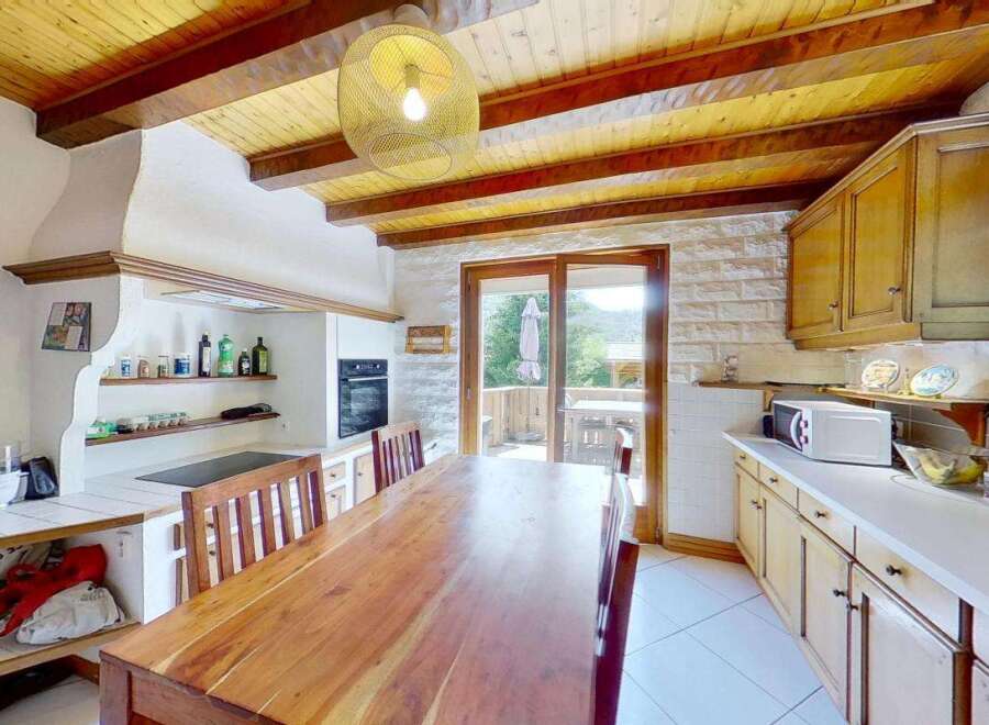 Discover this charming kitchen featuring a rustic wooden dining table perfect for family meals.