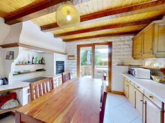 Discover this charming kitchen featuring a rustic wooden dining table perfect for family meals.