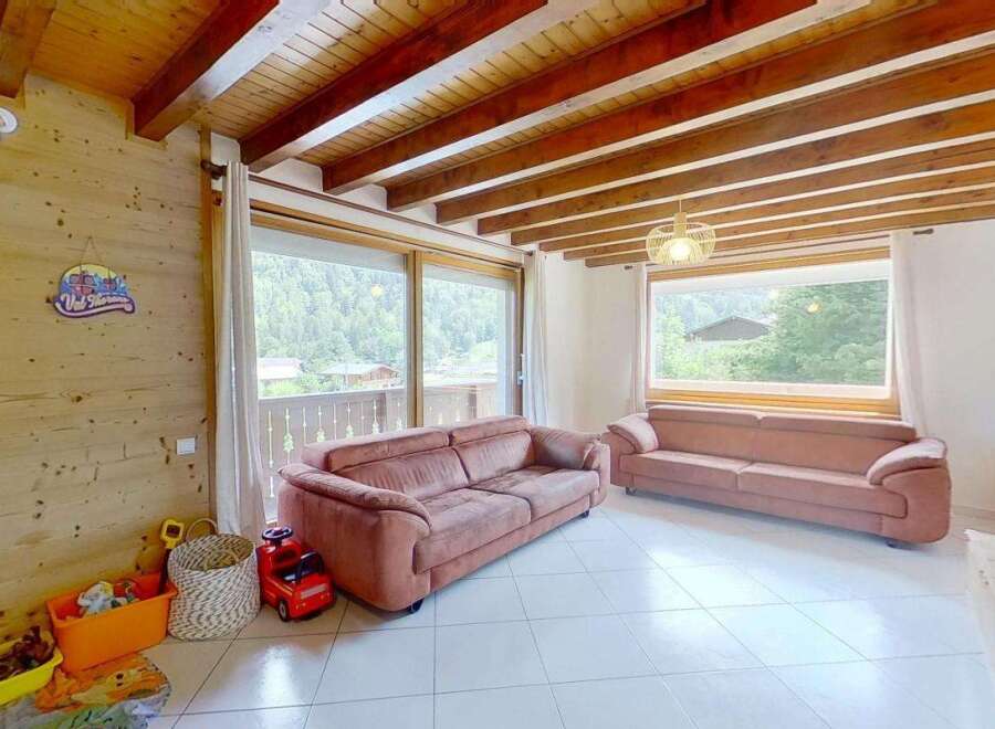 Experience cozy living in this charming mountain retreat, featuring exposed wooden beams and a warm, inviting atmosphere.
