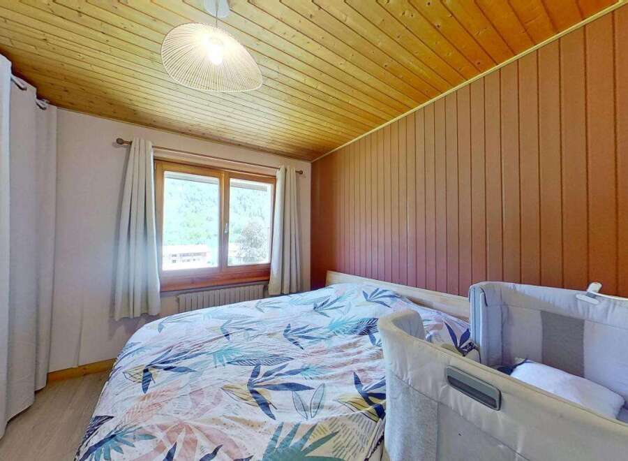 Experience cozy mountain living in this charming bedroom featuring a comfortable bed with a nature-inspired duvet cover.