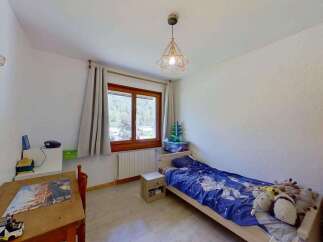Discover this charming bedroom featuring a cozy single bed with playful bedding and a collection of stuffed animals.