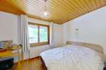 This charming bedroom features a cozy bed with white linens, perfect for relaxation.