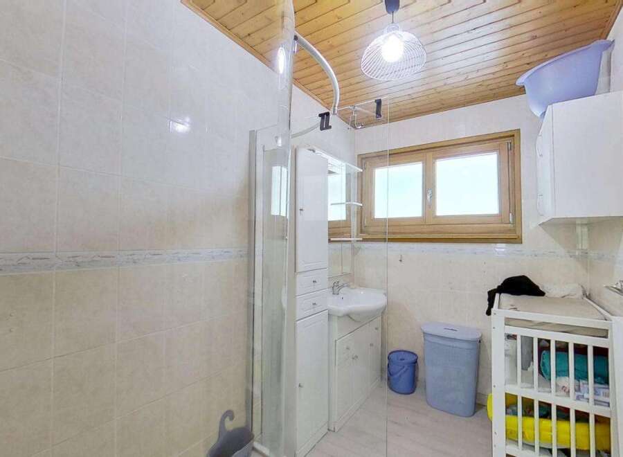 This charming bathroom features a modern shower enclosure and a sleek vanity with a sink, perfect for a quick refresh.