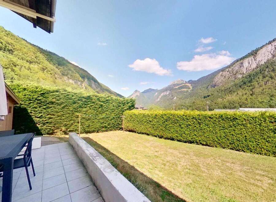 Enjoy breathtaking mountain views from this charming property's patio, complete with outdoor dining furniture and a large umbrella.
