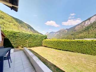 Enjoy breathtaking mountain views from this charming property's patio, complete with outdoor dining furniture and a large umbrella.