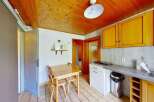 This charming kitchen features warm wooden ceilings and cabinets, creating a cozy and inviting atmosphere.