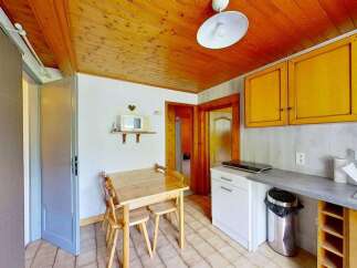 This charming kitchen features warm wooden ceilings and cabinets, creating a cozy and inviting atmosphere.