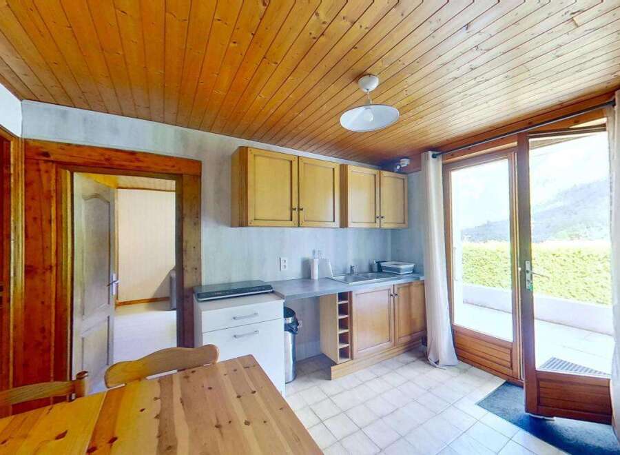 Discover this charming kitchen featuring warm wooden cabinetry and a spacious countertop perfect for meal preparation.