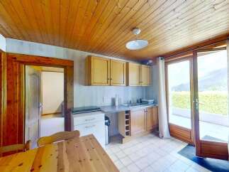 Discover this charming kitchen featuring warm wooden cabinetry and a spacious countertop perfect for meal preparation.