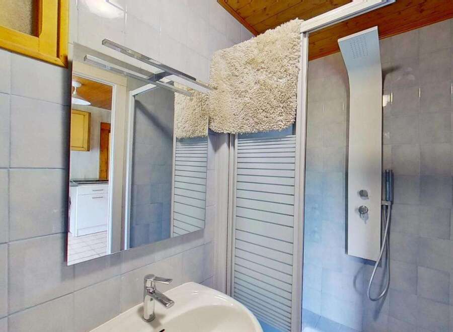This charming bathroom features a modern shower panel with a rainfall showerhead, perfect for a relaxing experience.
