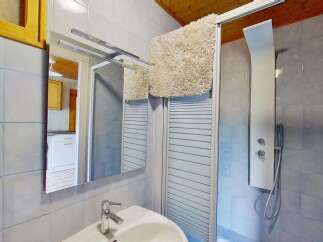 This charming bathroom features a modern shower panel with a rainfall showerhead, perfect for a relaxing experience.